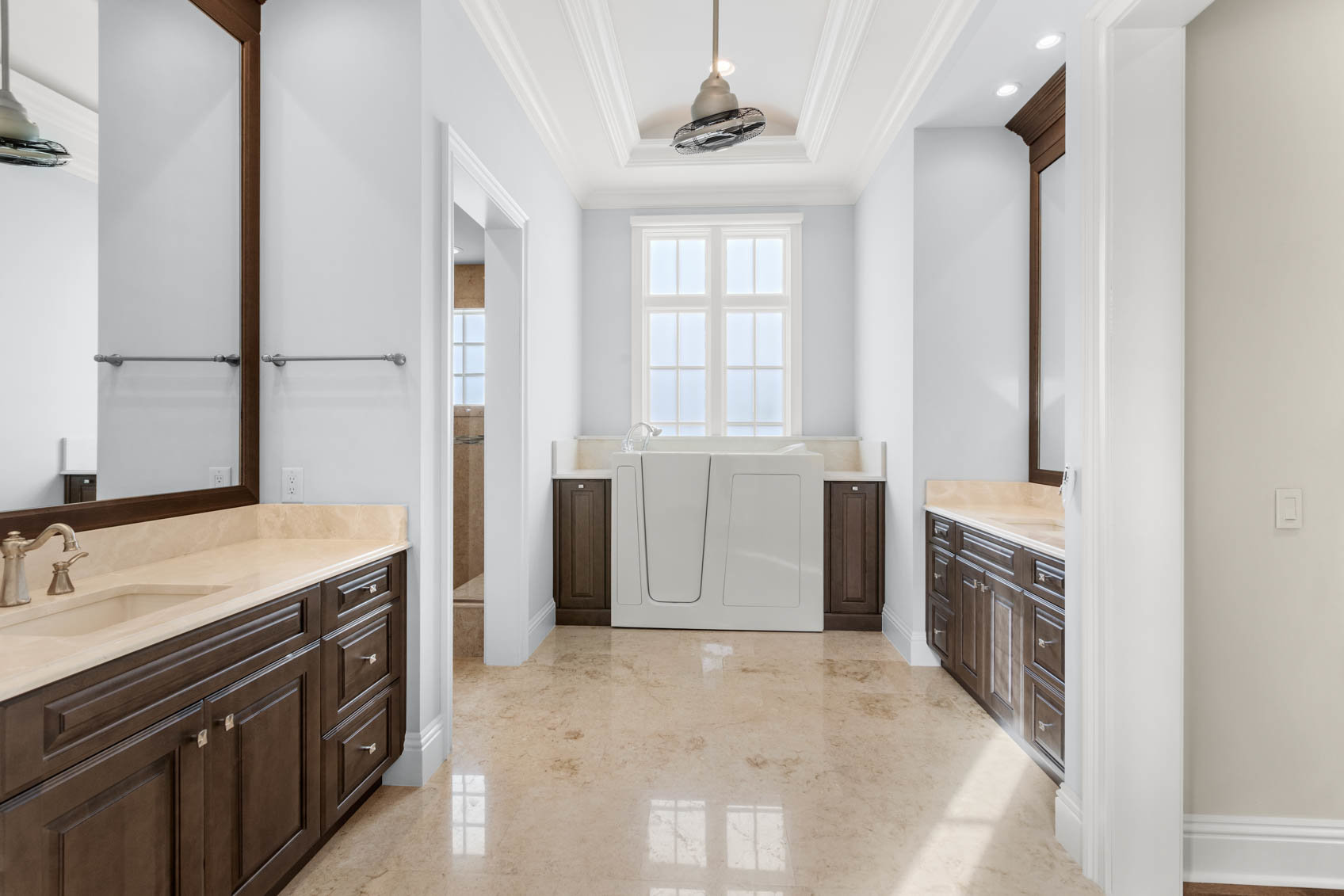 primary bathroom with sinks and tub